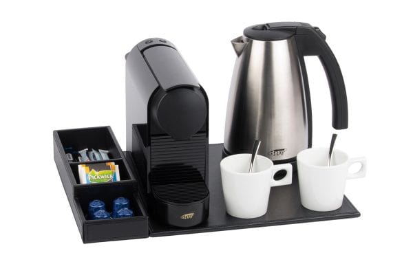 Black faux leather welcome tray for hotels with black small coffee machine, large stainless steel kettle and white cups